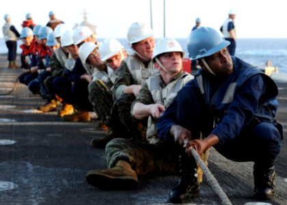 US Navy 100319-N-5538K-130 Sailors and Marines assigned to the forward-deployed amphibious transport dock ship USS Denver (LPD 9) hold a line to secure a span wire during a connected replenishment
