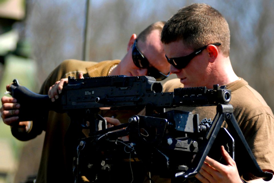 US Navy 100319-N-3136P-127 Hospital Corpsman 2nd Class Rocky Gann assists Gunner's Mate Seaman Rob Lotton, both assigned to Riverine Squadron (RIVRON) 1, assemble an M240 automatic machine gun during a six-day field exercise at