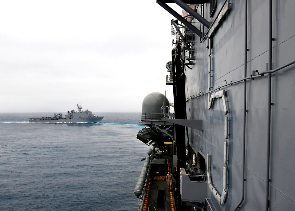 US Navy 100322-N-7948R-146 The amphibious dock landing ship USS Pearl Harbor (LSD 52) trails the amphibious assault ship USS Peleliu (LHA 5) off the coast of Southern California