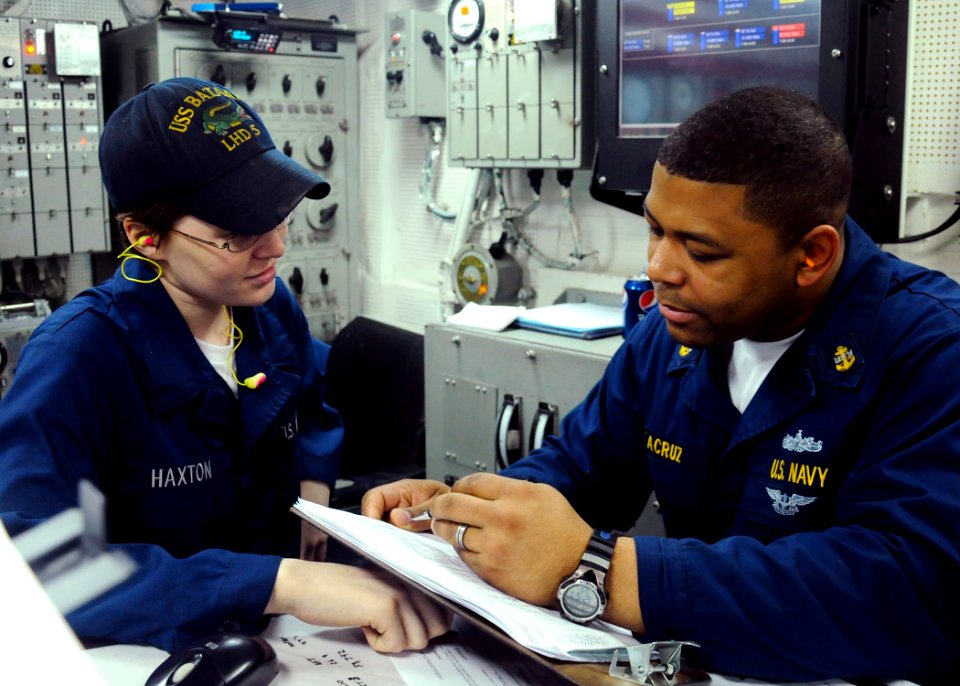 US Navy 100320-N-4649B-019 Chief Machinist's Mate Angel Delacruz, from New York, and Fireman Ashley Haxton, from Port Charlotte, Fla., review logs in the forward main machinery room