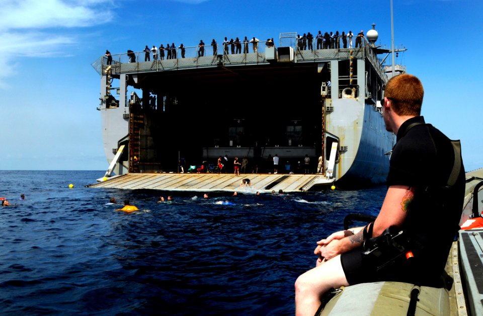 US Navy 100321-N-7948C-032 Engineman 3rd Class Bryce Tucker watches from a rigid-hull inflatable boat as Sailors participate in a swim call