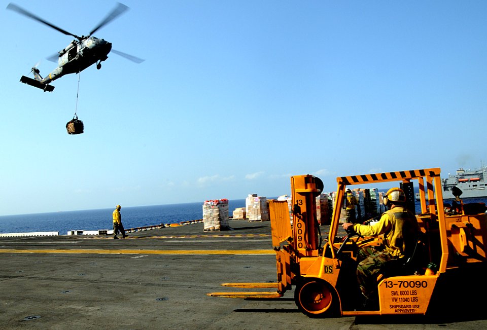 US Navy 100321-N-7508R-295 Sailors aboard the multipurpose amphibious assault ship USS Bataan (LHD 5) prepare to transport supplies during an underway replenishment