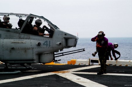US Navy 100322-N-1226D-161 Aviation Boatswain's Mate Airman Russell Hoyt and Aviation Boatswain's Mate (Fuel) 3rd Class Leonel Manzanilla tug on a refueling hose as they prepare to refuel an AH-1W Super Cobra helicopter