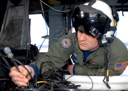 US Navy 100322-N-9520G-001 Naval Air Crewman 2nd Class William Rush, from Houston, assigned to Naval Air Station Whidbey Island Search and Rescue, conducts routine maintenance on an MH-60S Sea Hawk helicopter photo