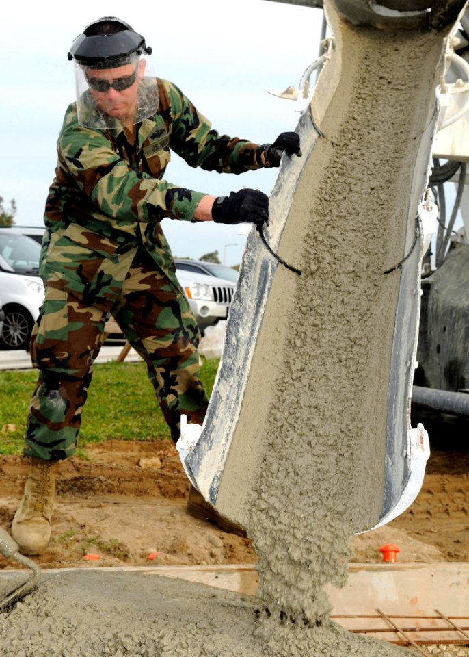 US Navy 100325-N-1120L-020 Builder 1st Class Brandon Simons monitors and places concrete for a new sidewalk at Naval Station Rota