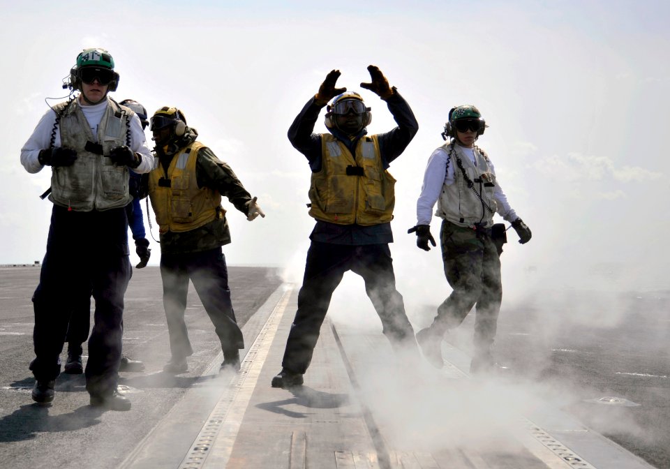 US Navy 100325-N-6003P-835 An Aviation Boatswain's Mate (Handling) signals an aircraft into launch position on the flight deck of the Nimitz-class aircraft carrier USS Harry S. Truman (CVN 75)