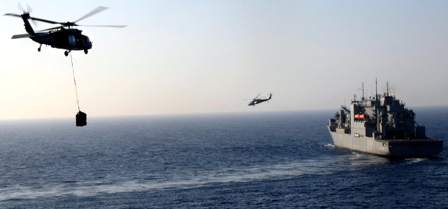 US Navy 100323-N-7508R-127 Helicopters transfer ammunition between the multipurpose amphibious assault ship USS Bataan (LHD 5) and the Military Sealift Command dry cargo and ammunition ship USNS Lewis and Clark (T-AKE 1)
