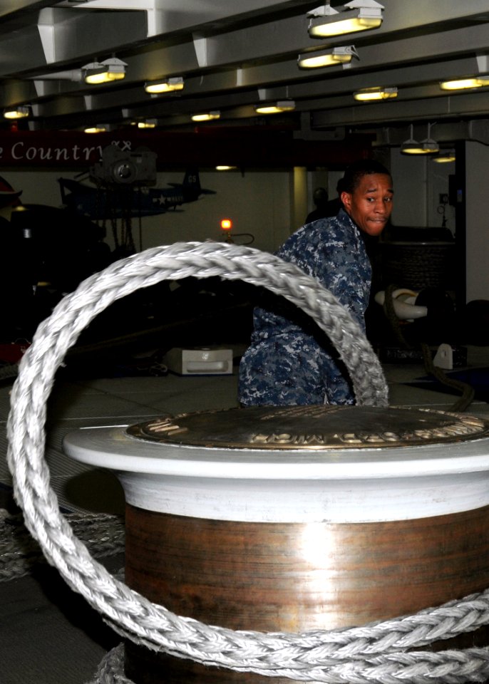 US Navy 100325-N-9116S-064 Seaman Marcus D. McDonald handles a mooring line on the forecastle aboard USS George H.W. Bush (CVN 77)
