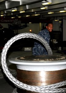 US Navy 100325-N-9116S-064 Seaman Marcus D. McDonald handles a mooring line on the forecastle aboard USS George H.W. Bush (CVN 77) photo