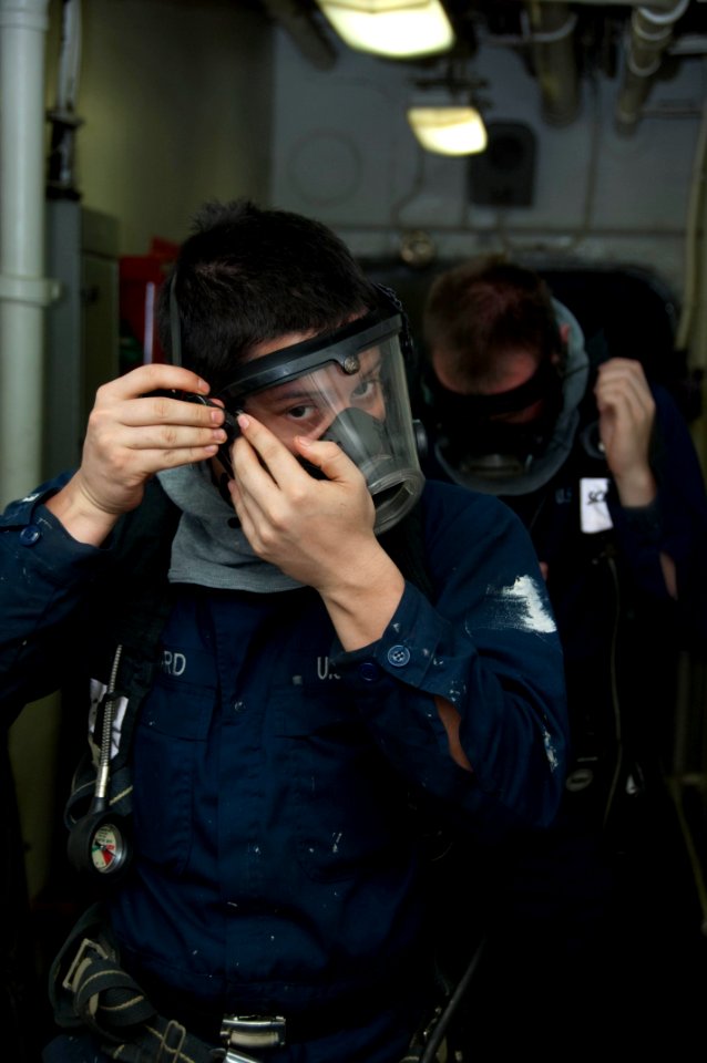 US Navy 100325-N-8936G-002 Fireman Tyler Harvard and Yeoman Seaman Recruit Christopher Lafrancois don self-contained breathing apparatuses during a damage control drill
