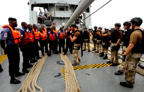 US Navy 100325-N-7948C-136 Interior Communications Electrician 3rd Class Matt Kopa, center, from Waymart, Pa., assigned to USS Gunston Hall (LSD 44), discusses boarding procedures with Nigerian sailors