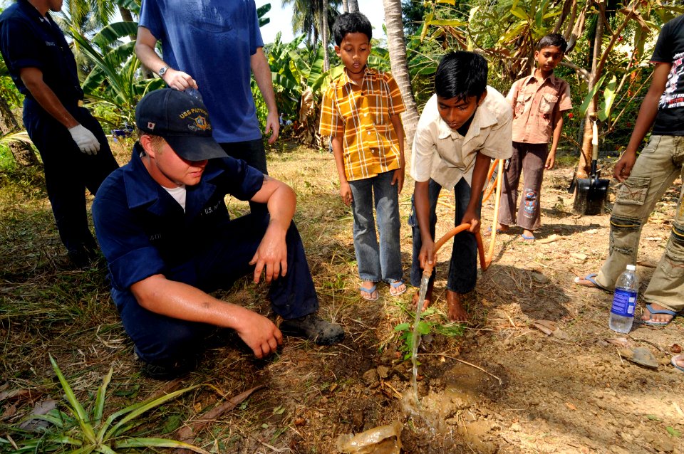 US Navy 100324-N-8335D-148 Mineman Seaman Derek Smith helps a boy from the Ramakrishna mission, an orphanage in Port Blair, plant a tree. Smith was one of 16 Sailors assigned to the mine countermeasures ship USS Patriot (MCM 7)