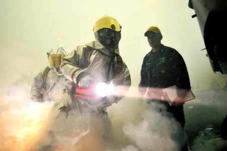 US Navy 100325-N-6003P-677 rash and salvage fire fighters check an F-A-18 Hornet for during a general quarters drill in the hangar bay aboard the Nimitz-class aircraft carrier USS Harry S. Truman (CVN 75)