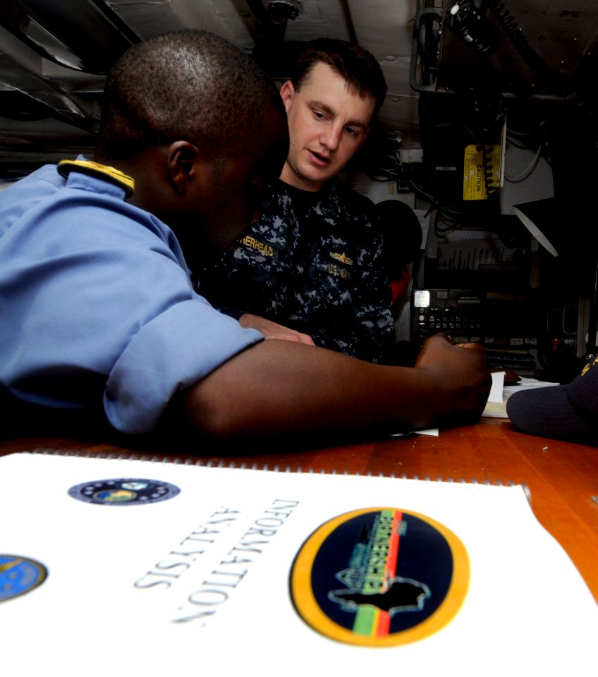 US Navy 100325-N-7948C-050 Lt. j.g. Douglas Weatherhead, from Handford, Calif., assigned to the Whidbey Island-class amphibious dock landing ship USS Gunston Hall (LSD 44), discusses navigation principles with a Nigerian navy o