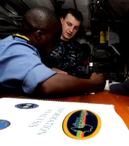 US Navy 100325-N-7948C-050 Lt. j.g. Douglas Weatherhead, from Handford, Calif., assigned to the Whidbey Island-class amphibious dock landing ship USS Gunston Hall (LSD 44), discusses navigation principles with a Nigerian navy o