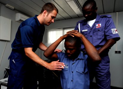 US Navy 100324-N-7948C-373 U.S. Coast Guard Maritime Law Enforcement Specialist Daniel Chase demonstrates proper personnel searching procedures to Nigerian and Ghanaian Sailors during a maritime law enforcement boarding officer