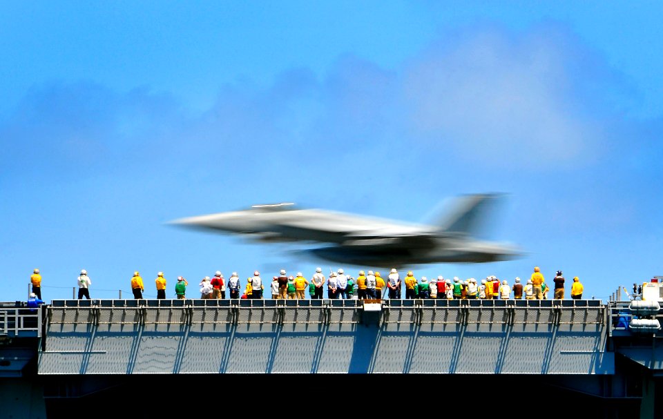 US Navy 100328-N-4774B-145 Crewmembers aboard the aircraft carrier USS Carl Vinson (CVN 70) observe an FA-18E Super Hornet assigned to the Sunliners of Strike Fighter Squadron (VFA) 81 lands during flight operations