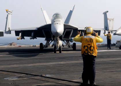 US Navy 100329-N-4236E-375 A Sailor directs an F-A-18E Super Hornet assigned to the Pukin Dogs of Strike Fighter Squadron (VFA) 143. across the flight deck of the Nimitz-class aircraft carrier USS Dwight D. Eisenhower (CVN 69)