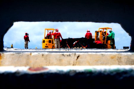 US Navy 100326-N-6006S-044 ailors aboard the aircraft carrier USS Carl Vinson (CVN 70) forklift supplies flown aboard from the Military Sealift Command fast combat support ship USNS Rainier (T-AOE 7) during a vertical replenish