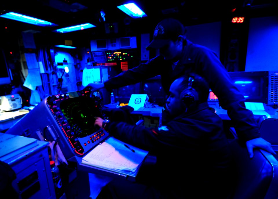 US Navy 100326-N-7948R-333 Operations Specialist 3rd Class Omar Iglesias and Ensign Kelsey Hausken track contacts from the Combat Information Center aboard the amphibious dock landing ship USS Pearl Harbor (LSD 52)