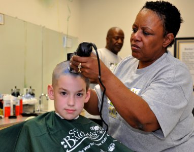 US Navy 100327-N-2541H-001 A little boy has his head shaved by a Navy Exchange barber during a St. Baldrick's Day fundraiser at Naval Medical Center Portsmouth photo