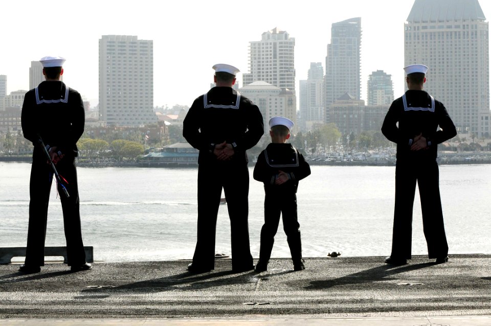 US Navy 100326-N-7939W-109 Machinist's Mate 1st Class Jay Hinton mans the rails with his son and other Nimitz Sailors on the flight deck of the aircraft carrier USS Nimitz (CVN 68) as the ship transits into its homeport at Nava