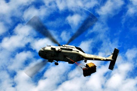 US Navy 100327-N-4774B-262 An SH-60F Sea Hawk helicopter, assigned to the Red Lions of Helicopter Anti-submarine Squadron (HS) 15, delivers supplies to the guided-missile cruiser USS Bunker Hill (CG 52) during a vertical replen