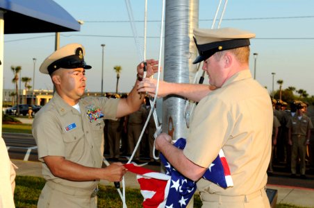 US Navy 100401-N-1522S-001 Chief Aviation Boatswain's Mate J.C. Travless and Chief Damage Controlman C.R. Tinkle prepare to raise the national ensign during morning colors in celebration of the chief petty officer's 117th birth photo