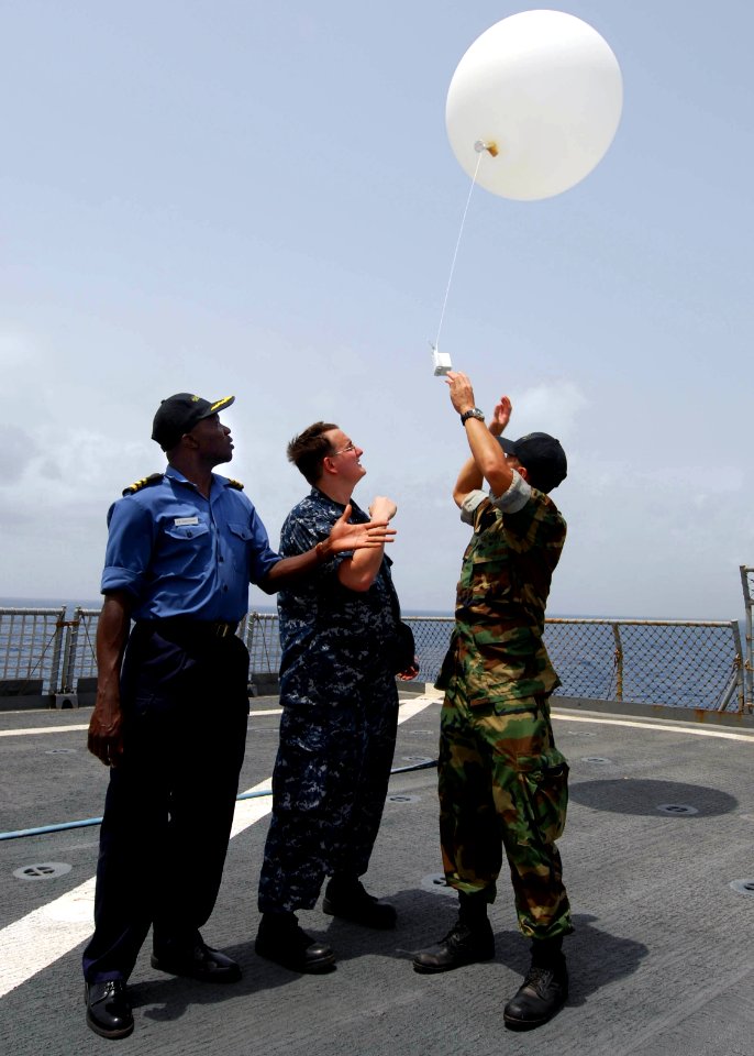 US Navy 100401-N-6138K-646 Nigerian navy Cmdr. Godffrey Kwetishe, left, Aerographer's Mate 2nd Class Cory Clare, from Apopka, Fla., and Lt. Brandon Le, from Monterey, Calif., launch a weather balloon