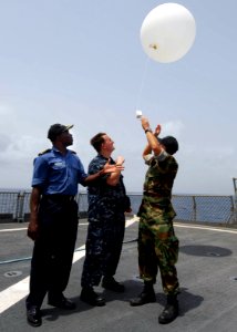 US Navy 100401-N-6138K-646 Nigerian navy Cmdr. Godffrey Kwetishe, left, Aerographer's Mate 2nd Class Cory Clare, from Apopka, Fla., and Lt. Brandon Le, from Monterey, Calif., launch a weather balloon