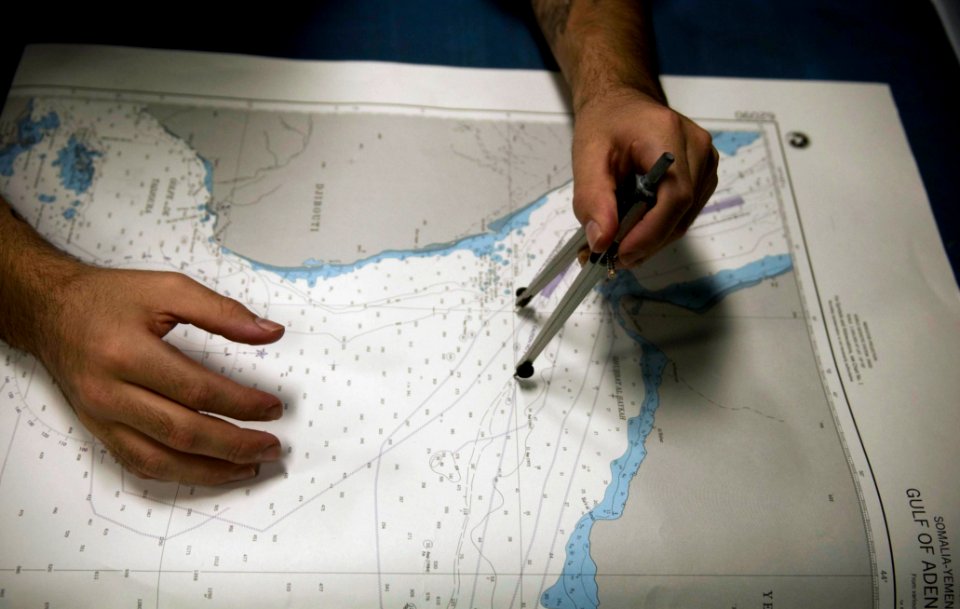US Navy 100405-N-5712P-135 Quartermaster 3rd Class Adalberto Fuentes, from Galveston, Texas, plots a course on a coastal chart in the chart room aboard the amphibious assault ship USS Nassau (LHA 4)