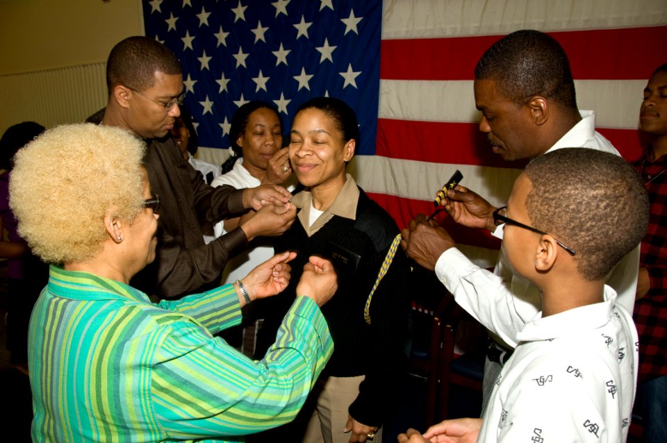 US Navy 100401-N-6724S-013 amily members place collar devices and shoulder boards on Cmdr. Allisa Walker during a promotion ceremony