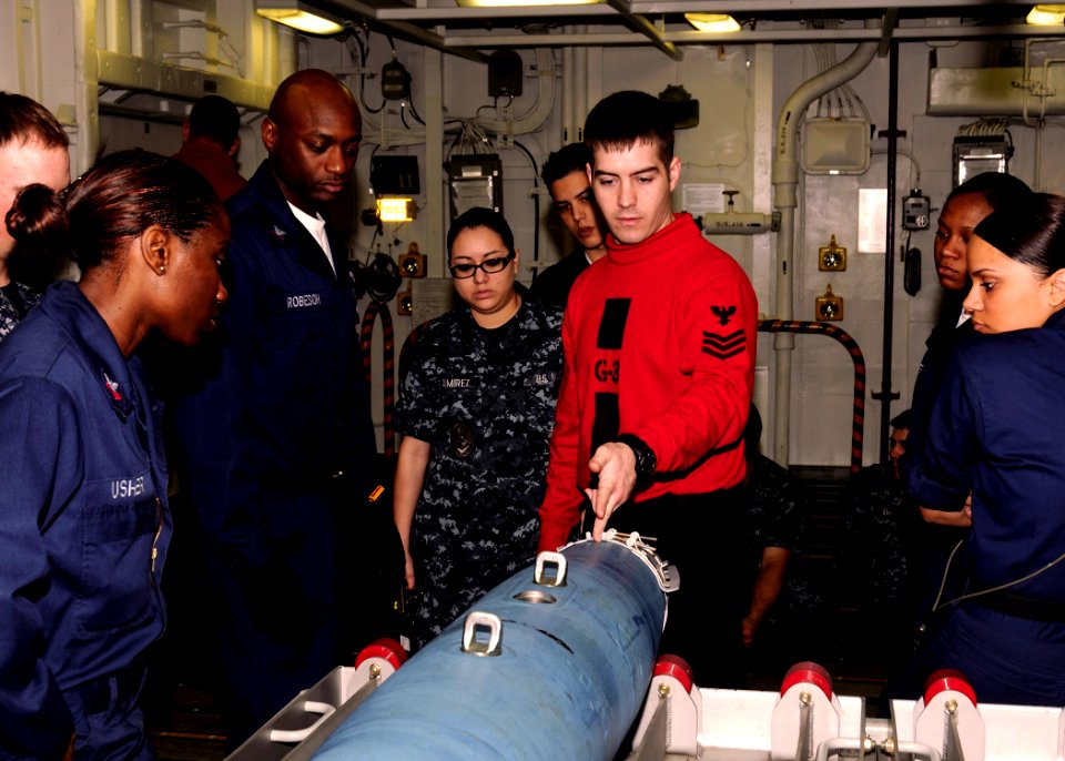 US Navy 100405-N-9116S-067 Aviation Ordnanceman 1st Class William J. Doyle instructs other Sailors on the assembly of an inert guided bomb