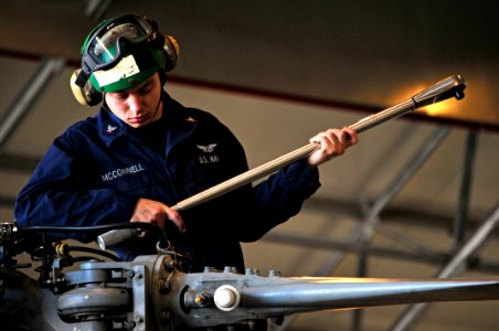 US Navy 100406-N-7364R-087 Aviation Machinist's Mate 3rd Class Jason McConell uses a torque wrench on the main rotor head of an MH-60S Sea Hawk helicopter