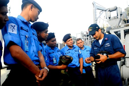 US Navy 100401-N-8335D-081 Damage Controlman 1st Class Arturo Chavez shows Royal Malaysian navy sailors an MCU-2P gas mask
