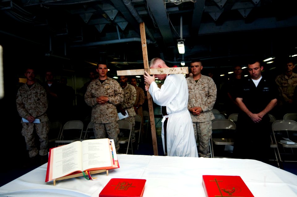 US Navy 100402-N-5712P-009 Lt. Jay Kersten holds up a wooden cross to symbolize the cross that Jesus was crucified on as Sailors celebrate Roman Catholic Mass