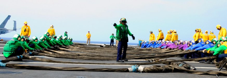 US Navy 100406-N-8913A-013 Aviation Boatswain's Mate (Equipment) 2nd Class Bennie L. Clark directs Sailors during a barricade drill