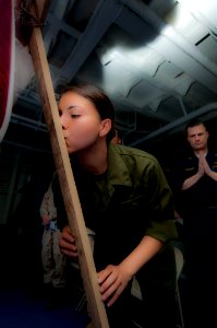 US Navy 100402-N-5712P-013 Cpl. Veronica Vazquez kisses a wooden cross that symbolizes the cross that Jesus was crucified on