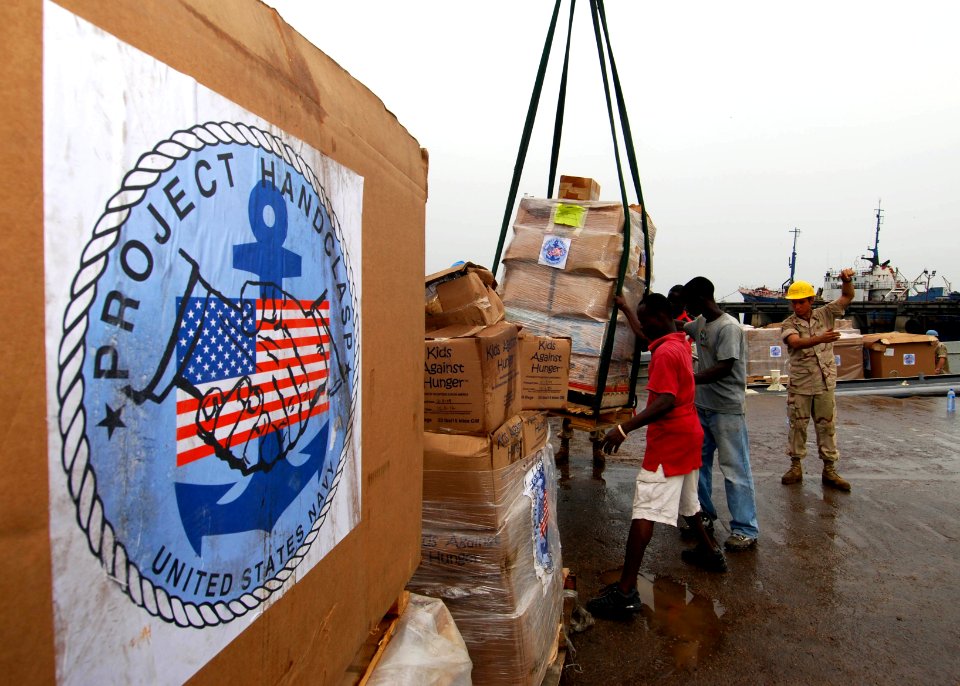 US Navy 100403-N-6138K-825 Sailors assigned to Naval Mobile Construction Battalion (NMCB) 7 and Assault Craft Unit (ACU) 2 offload Project Handclasp material
