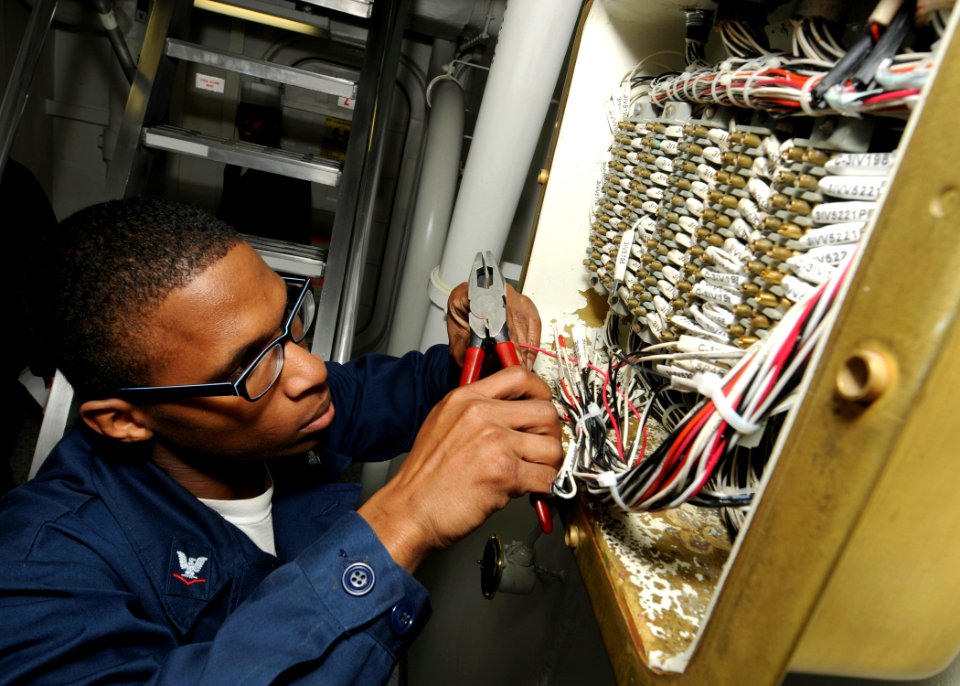 US Navy 100402-N-9116S-015 nterior Communications Electrician 3rd Class Larry O. Hughes, assigned to the combat systems department aboard the aircraft carrier USS George H.W. Bush (CVN 77), performs maintenance on the ship's in