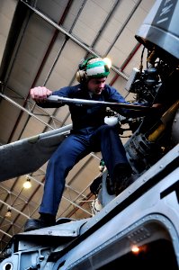 US Navy 100406-N-7364R-142 Aviation Machinist's Mate 2nd Class Scott Lister, assigned to the Dragonwhales of Helicopter Sea Combat Squadron (HSC) 28, performs maintenance on the main rotor head of an MH-60S Sea Hawk helicopter