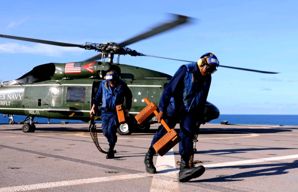 US Navy 100409-N-1675O-118 Seaman Drew Iverson and Operations Specialist 3rd Class Michael Sumlar remove chocks from an SH-60F Sea Hawk helicopter