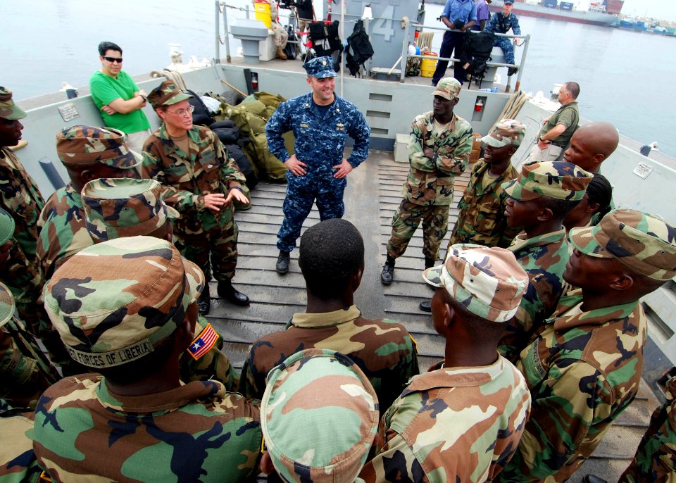 US Navy 100403-N-6138K-911 Capt. Cindy Thebaud, commander of Africa Partnership Station West, and Lt. Cmdr. Timothy Labenz, Africa Partnership Station operations officer, speak to a group of Armed Forces of Liberia Coast Guards