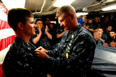 US Navy 100409-N-9818V-134 Master Chief Petty Officer of the Navy (MCPON) Rick West pins the Enlisted Submarine Warfare pin on the uniform of Electronics Technician 3rd Class Benjamin Chance