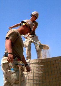 US Navy 100409-N-8816D-162 Steelworker Constructionman Stoney Wall, right, assigned to Naval Mobile Construction Battalion (NMCB) 133, Detachment 6, and an unidentified Seabee build a Hesco barrier