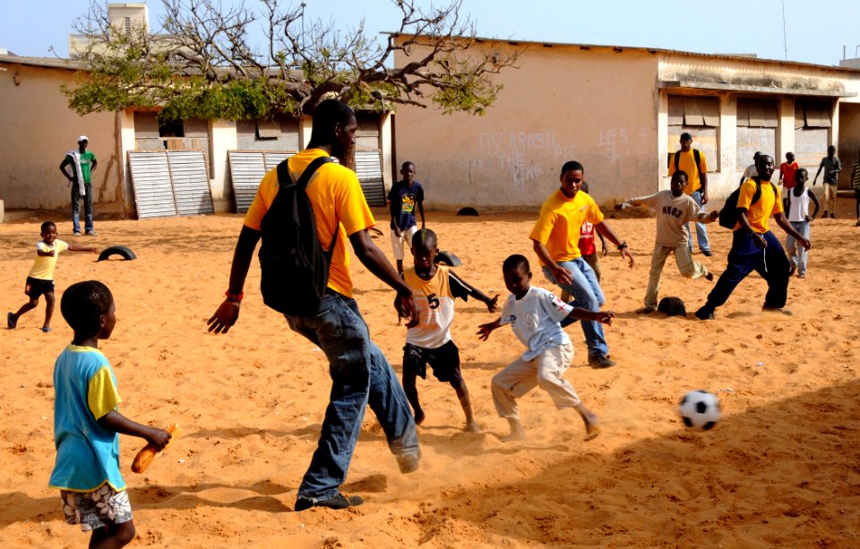 US Navy 100409-N-7948C-027 Boatswain's Mate Seaman Jean Petitfrere plays soccer with children during a community outreach project at Pikine17A and HLM Pekine grade school
