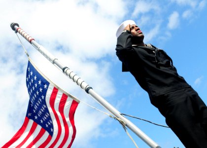 US Navy 100407-N-9301W-364 Boatswains Mate Seaman Apprentice Jacob Starks salutes during a burial at sea ceremony photo