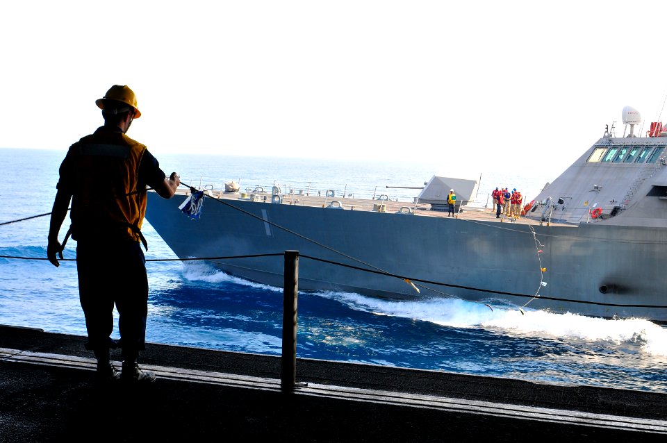 US Navy 100407-N-8878B-167 Boatswain's Mate 2nd Class Chris Payton, from Pasadena, Texas, guides the phone and distance lines connected to the littoral combat ship USS Freedom (LCS 1) during a refueling at sea