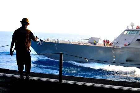 US Navy 100407-N-8878B-167 Boatswain's Mate 2nd Class Chris Payton, from Pasadena, Texas, guides the phone and distance lines connected to the littoral combat ship USS Freedom (LCS 1) during a refueling at sea
