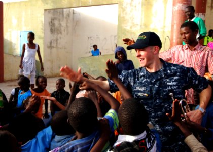 US Navy 100408-N-6138K-237 Musician 2nd Class Justin Strauss, a member of the U.S. Naval Forces Europe Band, Five Star Brass Quintet, high-fives children following a performance at the Colin Powell Cultural Center